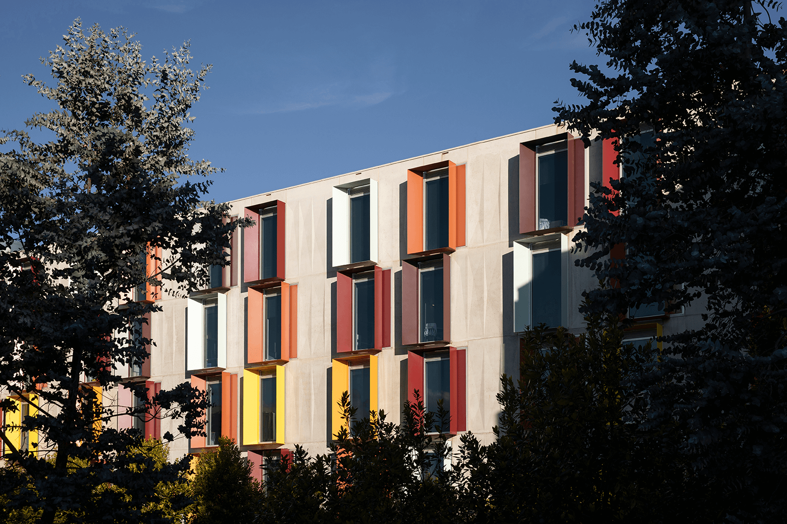 A shot of the side of a student accomodation building with lots of trees around