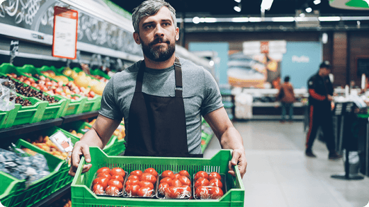 Supermarket-employee-holding-tomatos