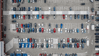 a looping gif of a busy car park from over head