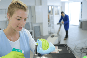 woman cleaning a surface with yellow gloves