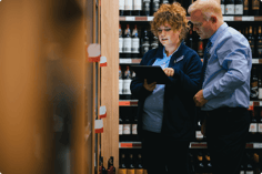 two-employees-look-at-tablet-in-supermarket