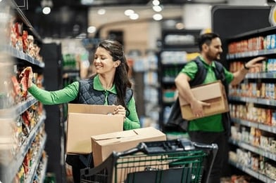 two-retail-employees-stock-shelves