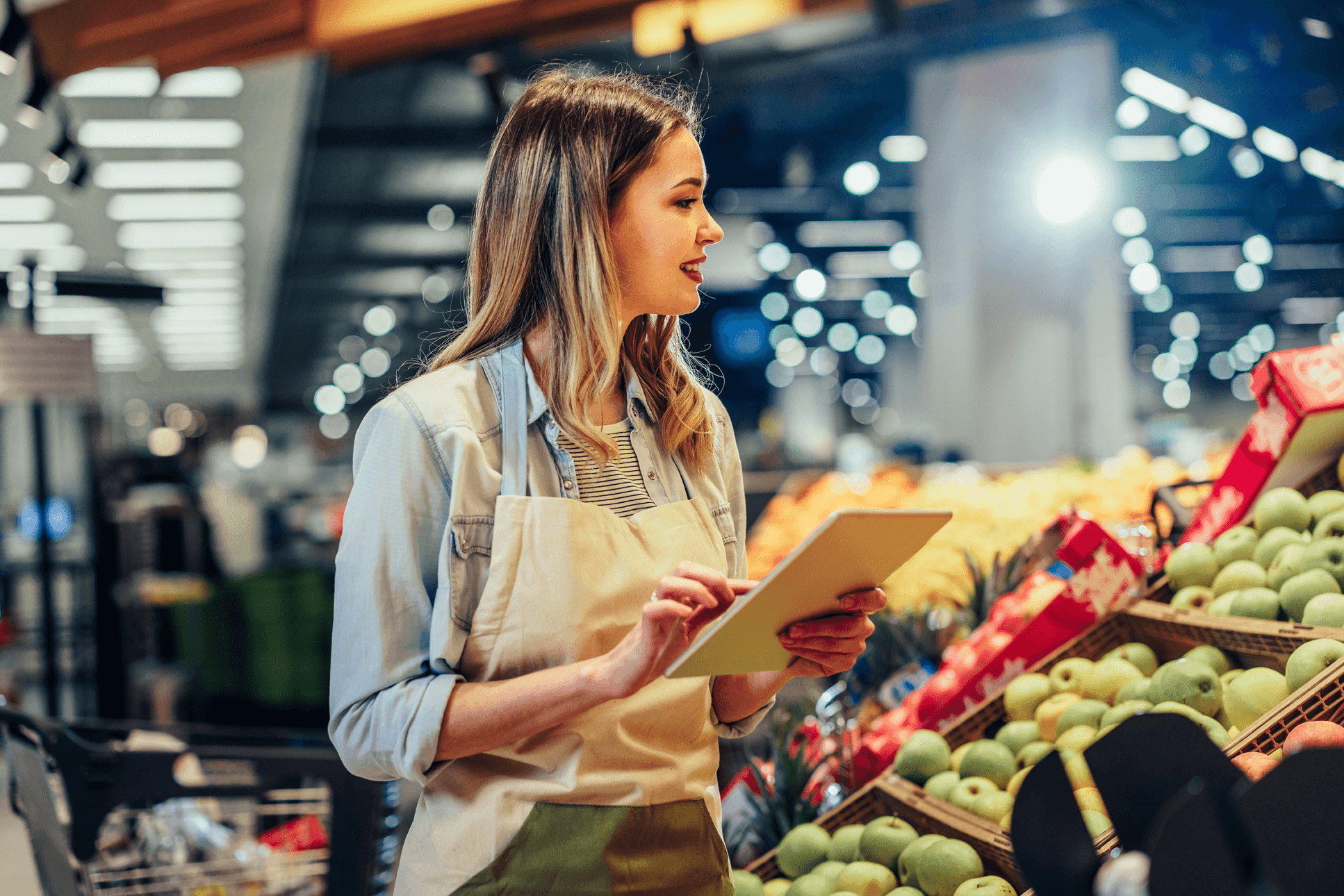 A supermarket employee checks stock with the help of a tablet application