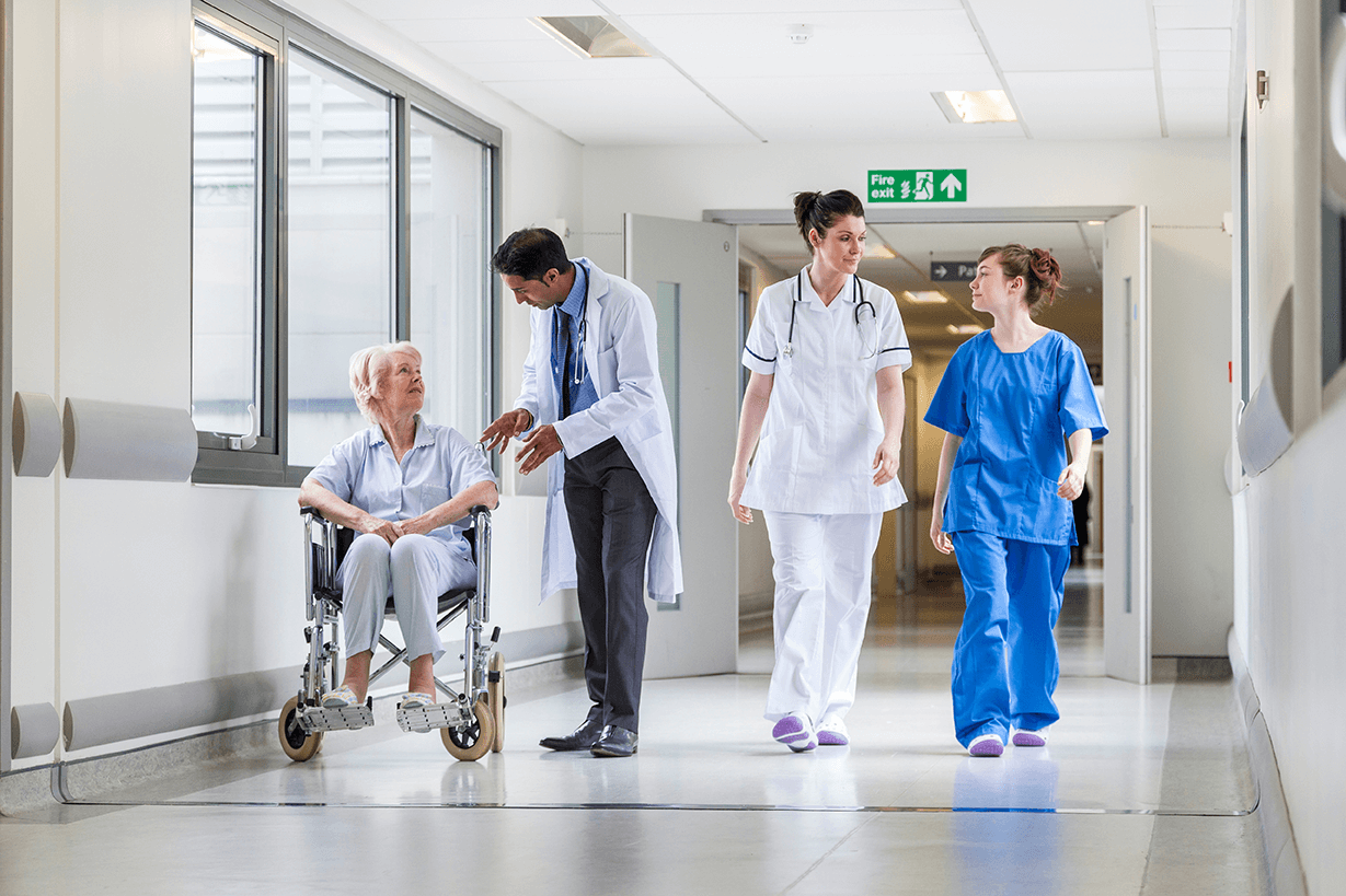 Two doctors, a nurse and a patient in a hospital corridor Two doctors, a nurse and a patient in a hospital corridor