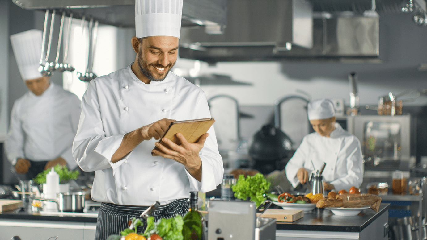 a chef checks his tablet for the daily menu