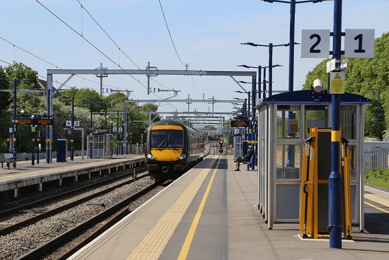 a train arrives at a station in sunny weather