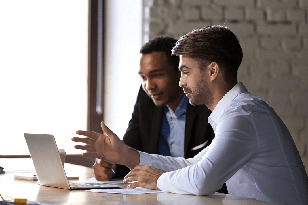 two facilities managers reviewing their operational data on a laptop